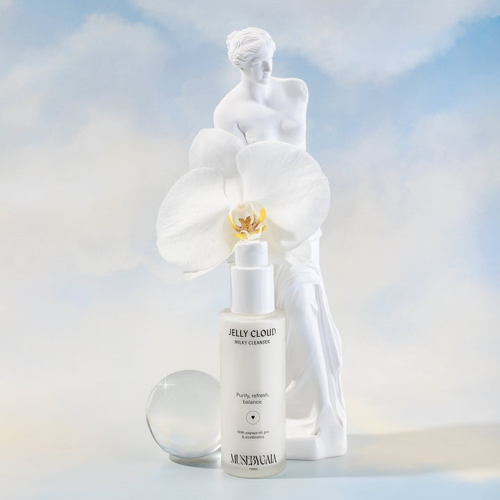 Muse by Gaia Jelly Cloud Milky Cleanser, featured with a statue and white orchid, available at VAMS Beauty Australian Skincare & Beauty Shop. This gentle facial cleanser purifies, refreshes, and balances the skin using papaya oil, prebiotics, and postbiotics. Ideal for a radiant and hydrated complexion.