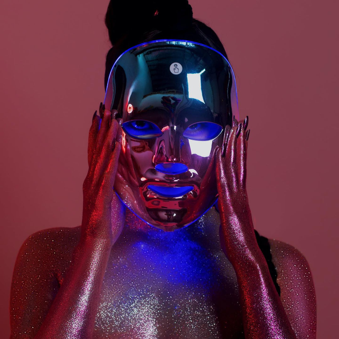 A person with glittery skin wearing an LED therapy face mask, showcasing a futuristic beauty treatment popular among Australian skincare aficionados.