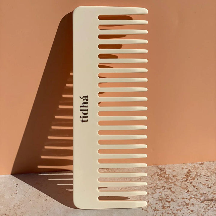 Sustainable tidhá branded detangling comb made of biodegradable material, showcased on a plain background. The comb’s beige color and eco-friendly design make it an attractive choice for environmentally conscious consumers looking for haircare tools