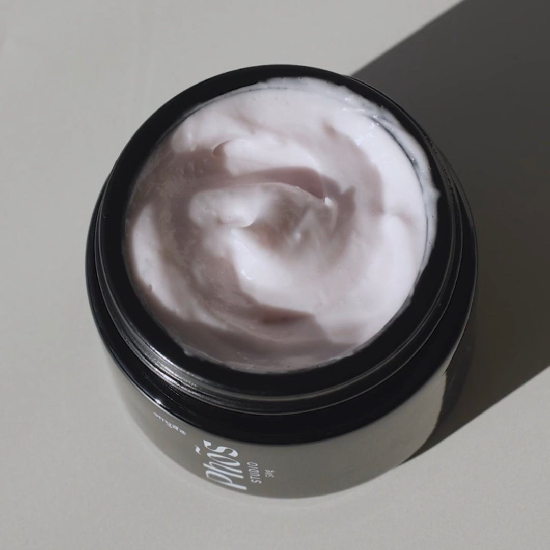Open jar of Phos studio luxurious night cream with a whipped texture, casting a soft shadow in natural light, highlighting the rich and hydrating formula designed to rejuvenate the skin during sleep.